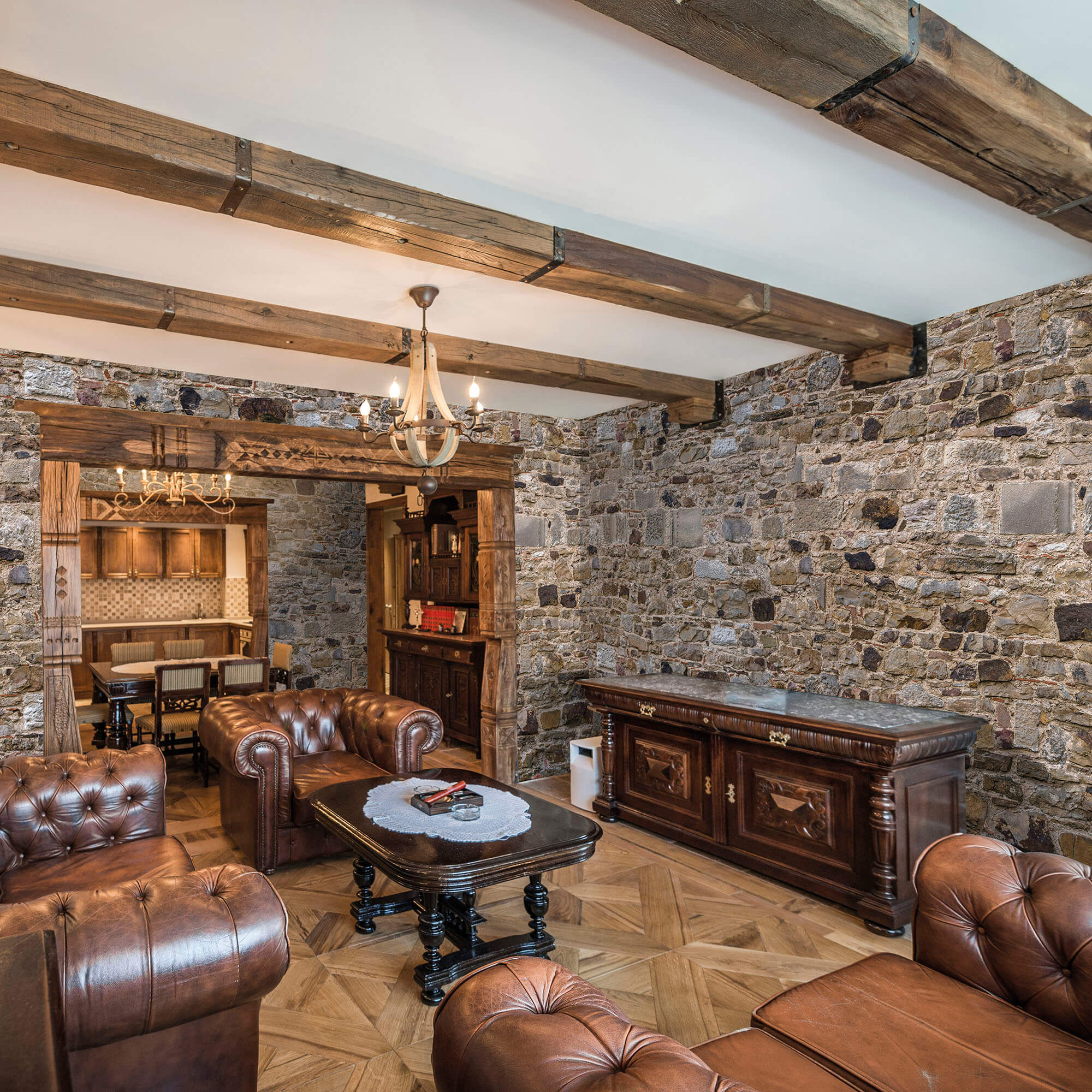 Living room interior with wooden ceiling beams and stoned walls